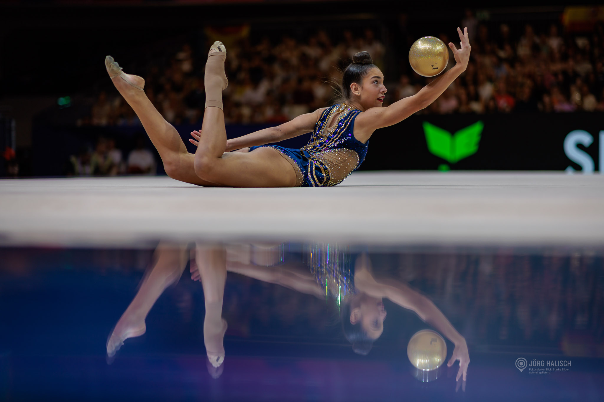 Sportgymnastin in blauem Wettkampfanzug zeigt eine spektakuläre einarmige Balance mit dem Ball bei der Weltmeisterschaft der Rhythmischen Sportgymnastik in Frankfurt am Main 2026.